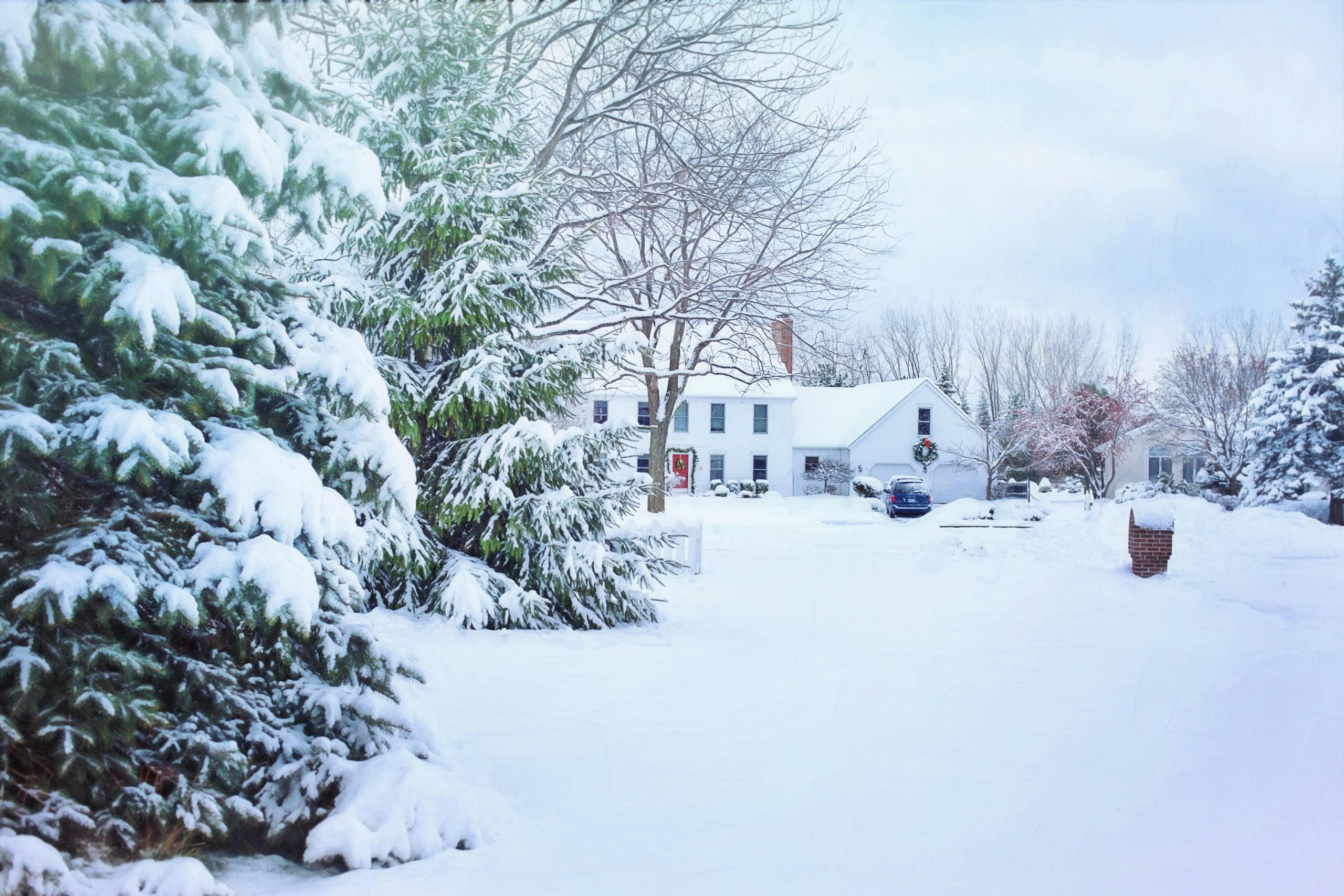 Massachusetts home exterior in winter with snow, gutters cleared and lights on inside—prepared for seasonal home maintenance.”
